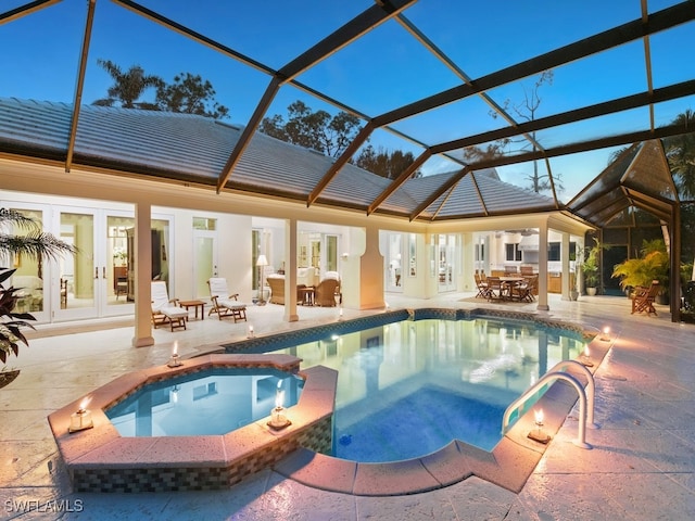 view of swimming pool with an in ground hot tub, french doors, a patio, and glass enclosure