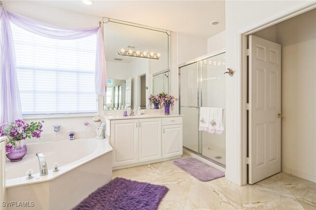 bathroom with vanity and independent shower and bath