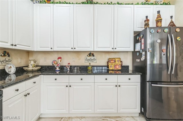 kitchen with stainless steel refrigerator and white cabinets