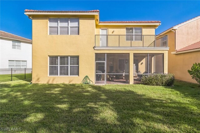 back of property featuring a sunroom, a yard, and a balcony