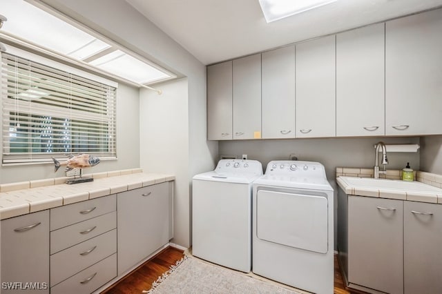 laundry room with sink, cabinets, dark wood-type flooring, and washing machine and clothes dryer