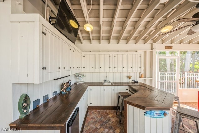 kitchen with kitchen peninsula, sink, and white cabinets