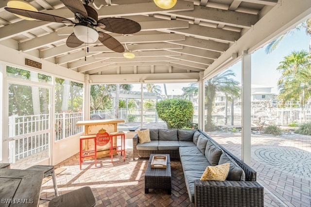 sunroom with ceiling fan, lofted ceiling, and a wealth of natural light