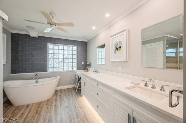 bathroom with hardwood / wood-style floors, vanity, a bath, and ornamental molding