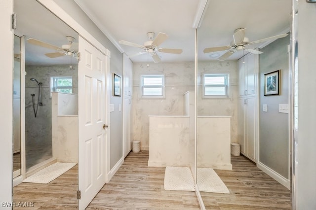 bathroom with hardwood / wood-style floors, plenty of natural light, and tiled shower