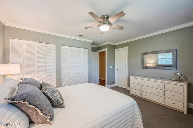 carpeted bedroom featuring ceiling fan, two closets, and ornamental molding