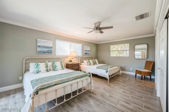 bedroom featuring light wood-type flooring, multiple windows, ornamental molding, and ceiling fan