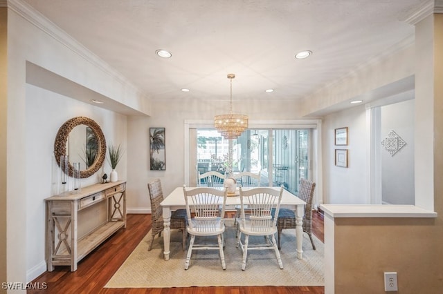 dining room featuring dark hardwood / wood-style floors, an inviting chandelier, and crown molding