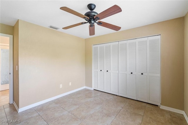 unfurnished bedroom featuring a closet, ceiling fan, and light tile patterned flooring