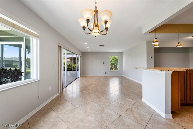 unfurnished room featuring plenty of natural light, light tile patterned floors, and a chandelier