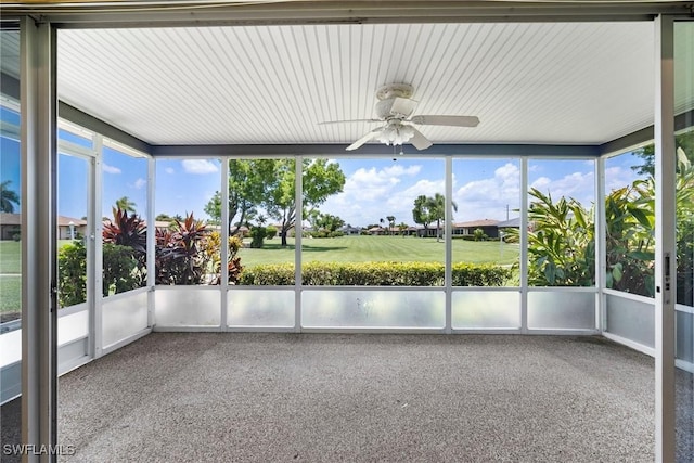 unfurnished sunroom featuring ceiling fan