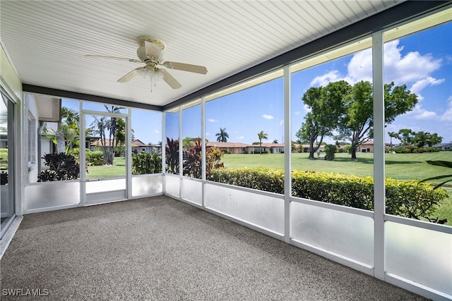 unfurnished sunroom featuring ceiling fan