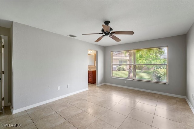 spare room with ceiling fan, plenty of natural light, and light tile patterned flooring