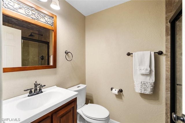 bathroom featuring vanity, toilet, and a shower with shower door