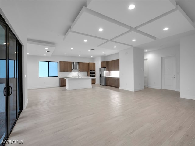 unfurnished living room with sink, light wood-type flooring, and coffered ceiling