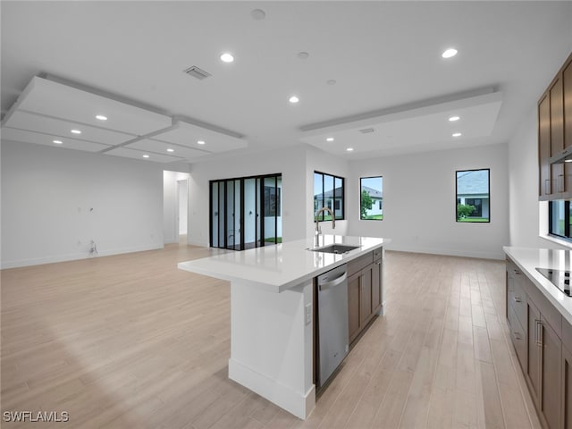 kitchen with light hardwood / wood-style floors, a center island with sink, sink, and dishwasher