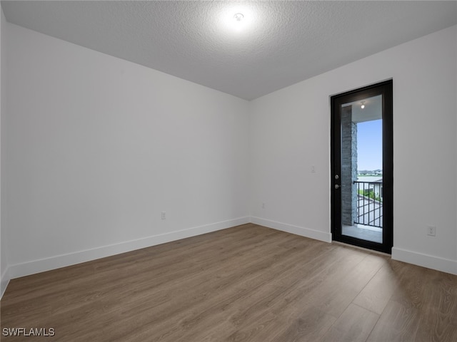 empty room featuring a textured ceiling and hardwood / wood-style flooring