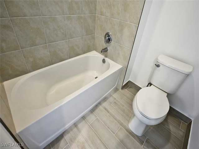 bathroom featuring tiled shower / bath and toilet