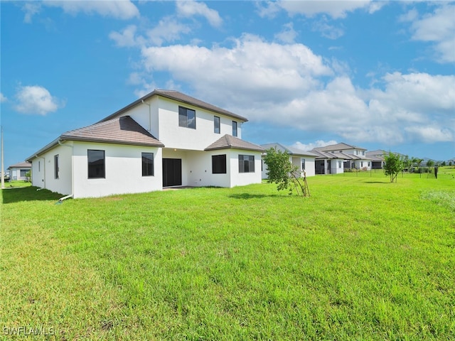 rear view of property featuring a yard