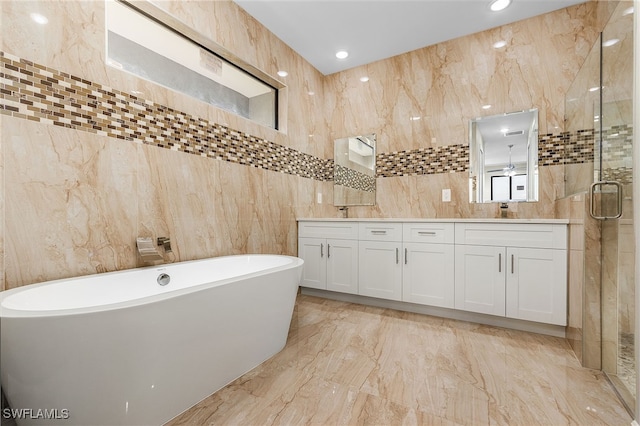 bathroom featuring tile walls, vanity, ceiling fan, and plus walk in shower