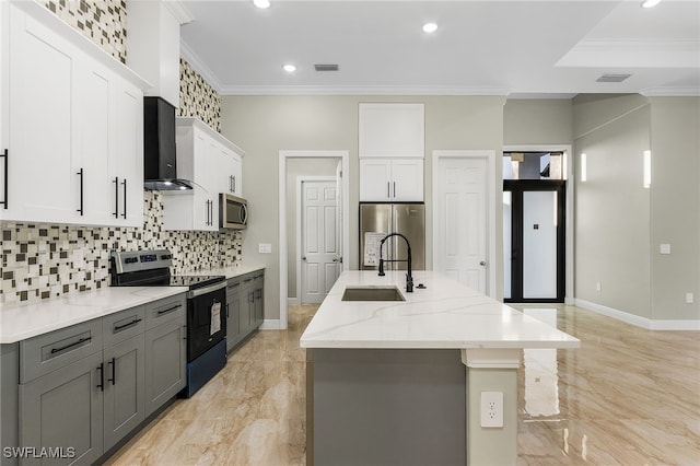 kitchen featuring stainless steel appliances, white cabinetry, sink, wall chimney exhaust hood, and an island with sink