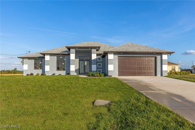 prairie-style house with a garage and a front lawn