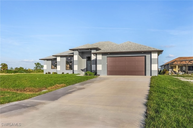 prairie-style house featuring a garage and a front lawn