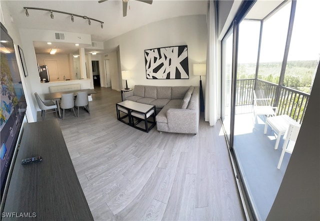 living room featuring rail lighting, wood-type flooring, and ceiling fan