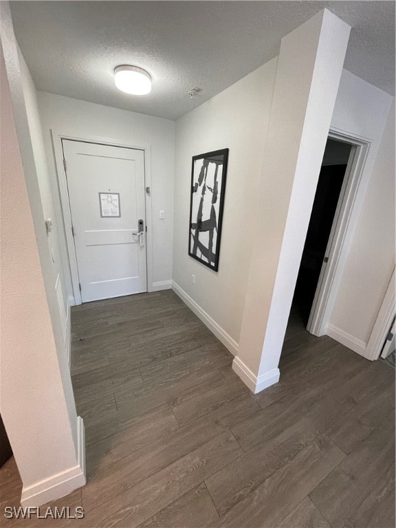 interior space featuring a textured ceiling and dark hardwood / wood-style floors