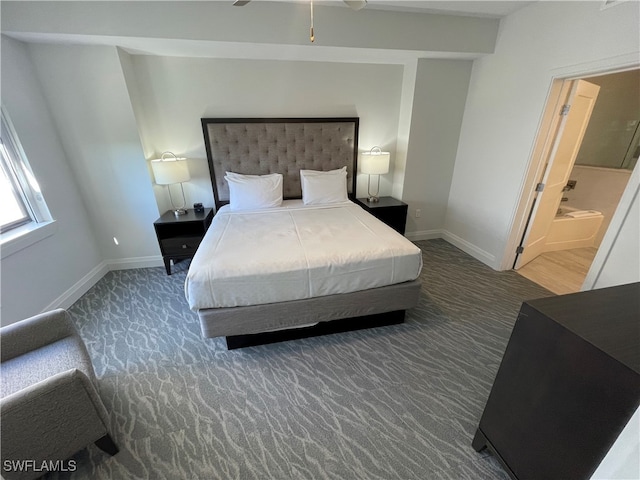 bedroom with ensuite bath and dark carpet