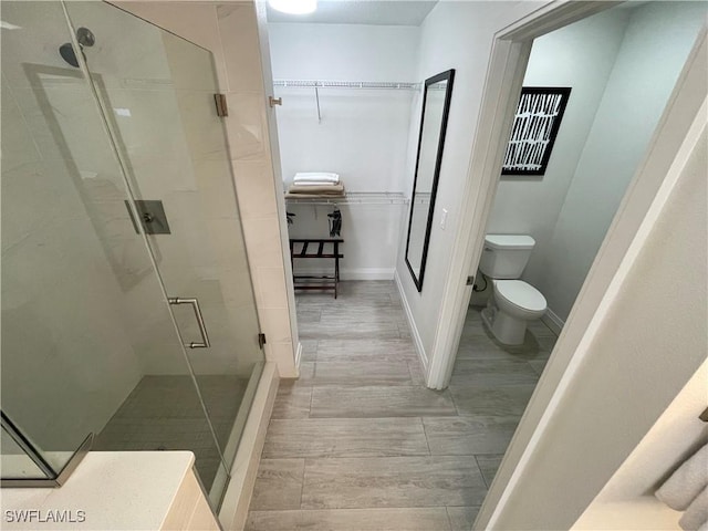 14501 Grove Resort Ave Unit 3712, Winter Garden, FL 34787 - full bath with wood finished floors, toilet, baseboards, a walk in closet, and a stall shower