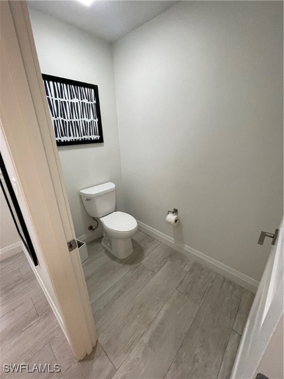 bathroom featuring toilet and wood-type flooring