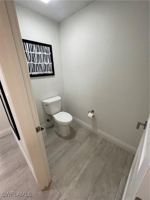 14501 Grove Resort Ave Unit 3712, Winter Garden, FL 34787 - bathroom featuring baseboards, wood finish floors, and toilet