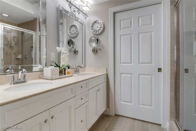 bathroom with hardwood / wood-style floors, vanity, and an enclosed shower