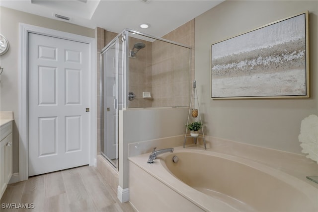 bathroom featuring wood-type flooring, vanity, and independent shower and bath