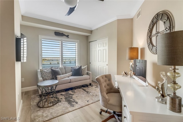 home office featuring ceiling fan, crown molding, and light wood-type flooring