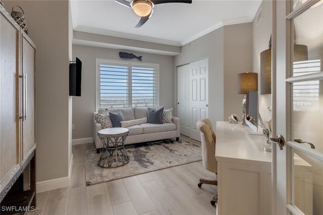 office space featuring ceiling fan, ornamental molding, and light wood-type flooring