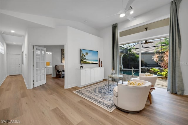 living room with ceiling fan and light hardwood / wood-style flooring