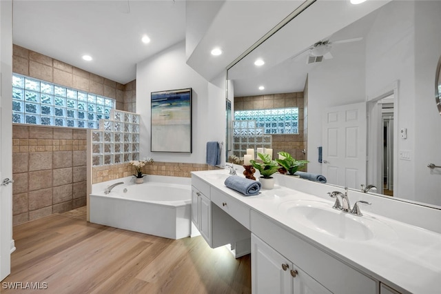 bathroom featuring vanity, wood-type flooring, tile walls, and shower with separate bathtub