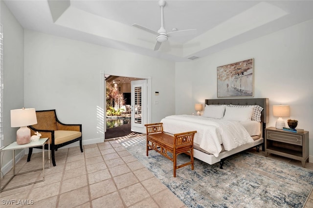 bedroom featuring ceiling fan, access to exterior, and a raised ceiling