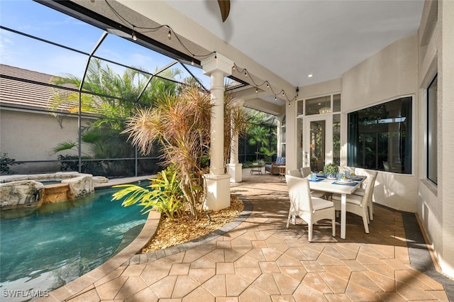 view of patio / terrace with a lanai, ceiling fan, and a pool with hot tub