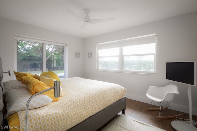 bedroom with multiple windows, wood-type flooring, and ceiling fan