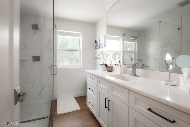 bathroom with an enclosed shower, vanity, and hardwood / wood-style floors