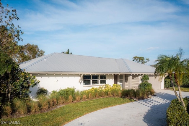 ranch-style house featuring a garage, a front lawn, stucco siding, and driveway