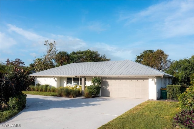 ranch-style home with a garage, stucco siding, driveway, and metal roof