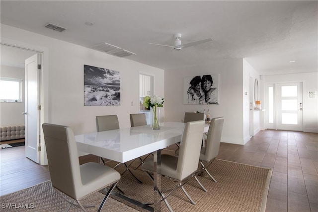 dining room with baseboards, ceiling fan, visible vents, and wood finished floors
