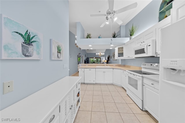 kitchen with white cabinetry, kitchen peninsula, a towering ceiling, white appliances, and light tile patterned floors