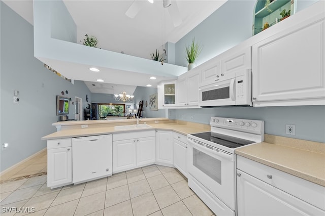 kitchen with vaulted ceiling, kitchen peninsula, white cabinetry, and white appliances