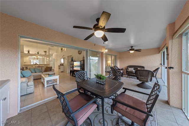 dining space featuring ceiling fan with notable chandelier and light tile patterned flooring