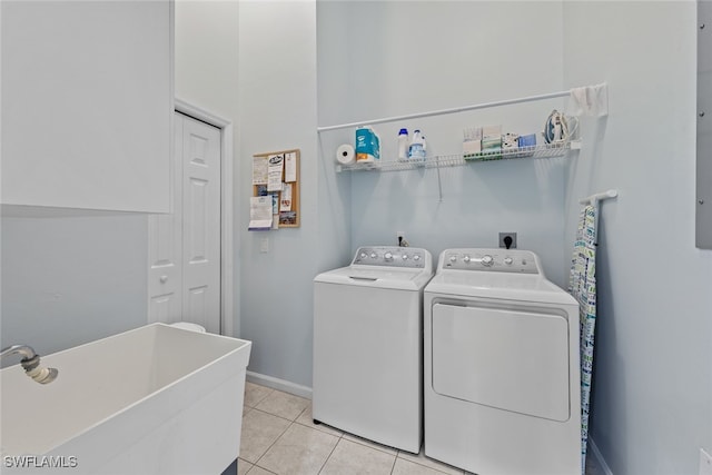 washroom featuring washer and clothes dryer, light tile patterned flooring, and sink